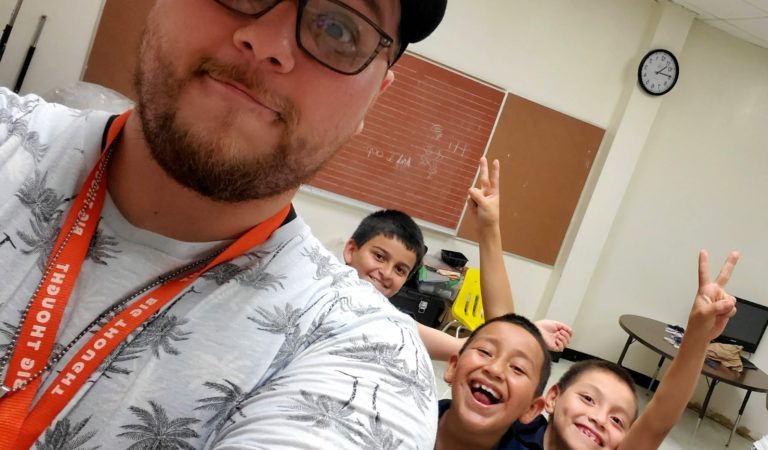 teacher standing smiling with students